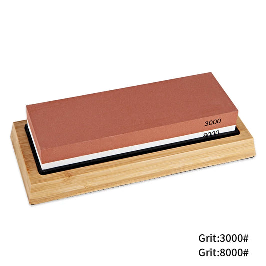 Double-sided sharpening stone with grit 3000 and 8000 on a wooden base.