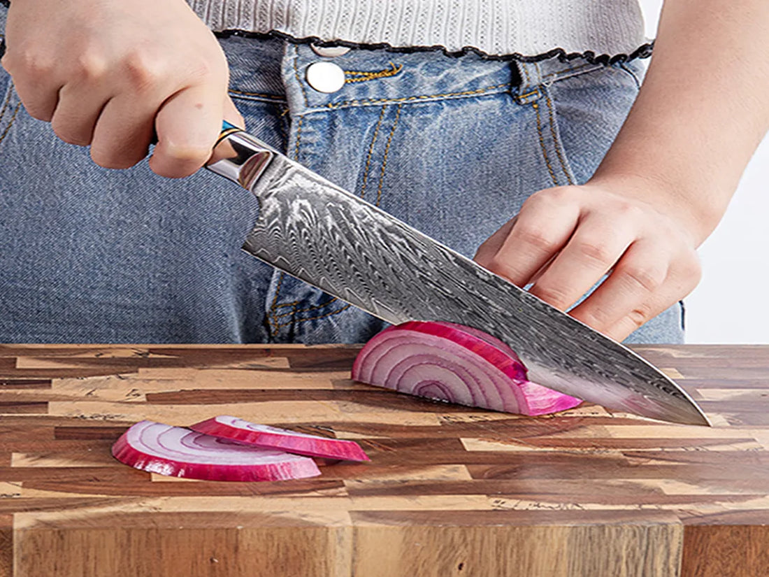 Professional Japanese VG10 Damascus steel chef knife cutting onion on wooden board