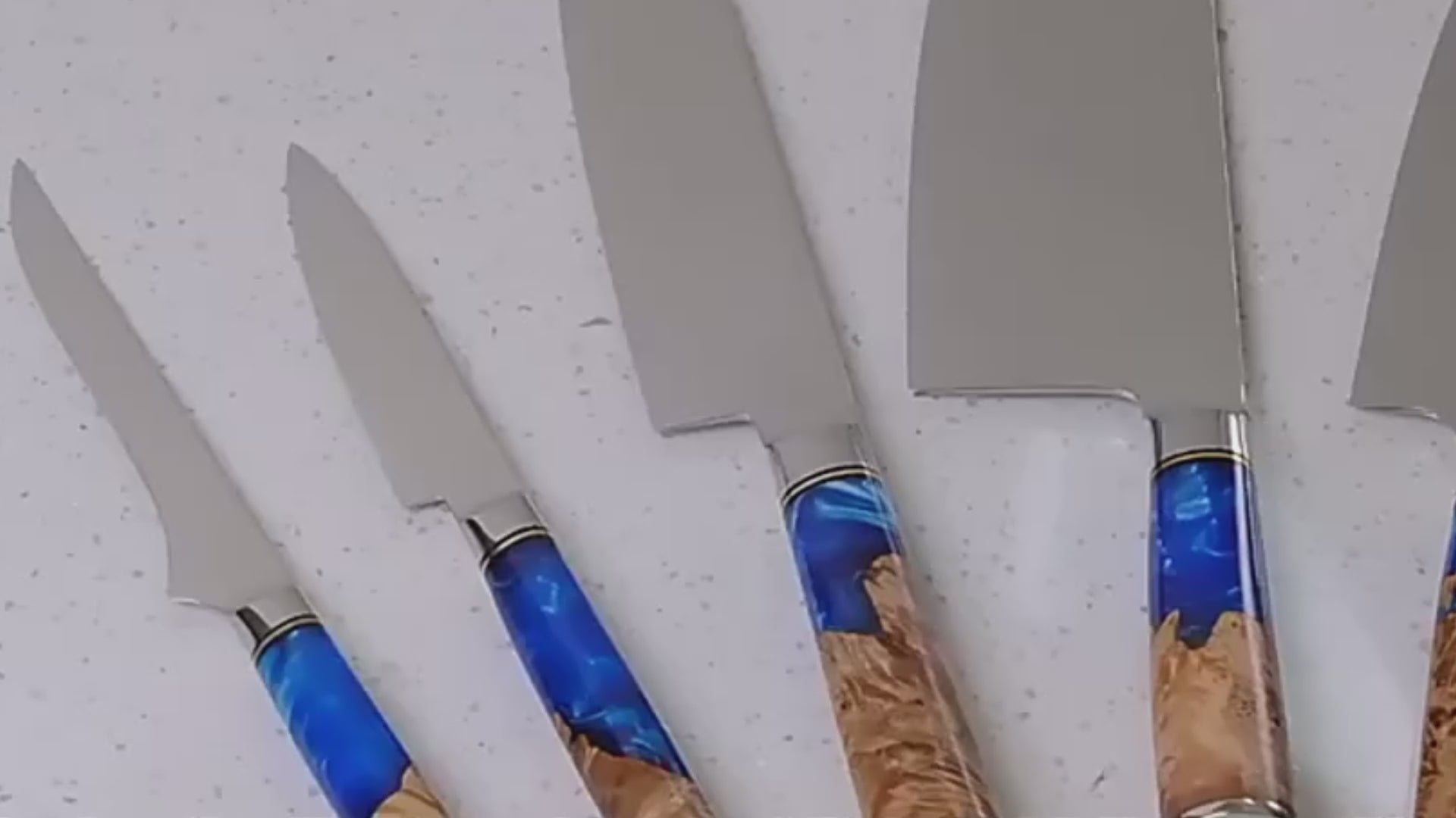 Cargar video: Close-up of a Damascus steel knife slicing raw meat smoothly on a wooden cutting board