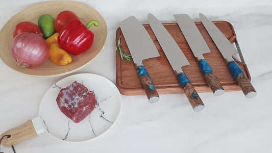 Damascus steel chef knife with blue resin handle slicing vegetables on a wooden cutting board in a modern kitchen