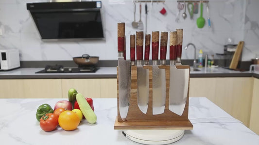 Close-up of ultra sharp Damascus steel kitchen knife with red resin handle slicing food smoothly on a wooden cutting board in a modern kitchen