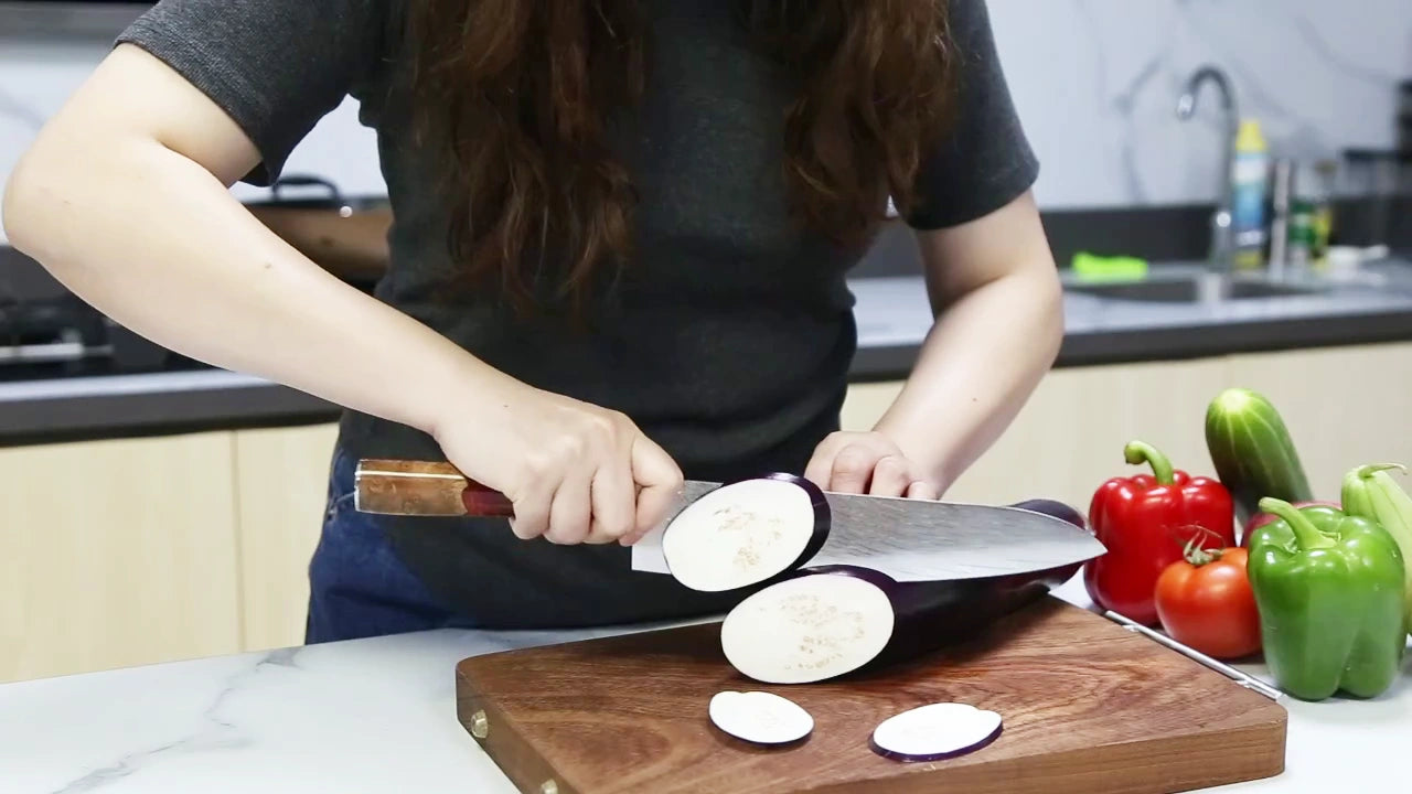 Carregar vídeo: Video demo of 9 inch Damascus chef knife with red resin ergonomic handle and ultra sharp patterned blade for professional kitchen slicing and food preparation